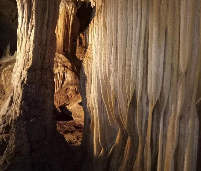 Bên trong hai ngách nhỏ có những đường viền nhũ đá, chỗ mềm mại uyển chuyển, chỗ lại mang dáng vẻ sắc nhọn với vô số hạt kết tinh sáng lấp lánh.
