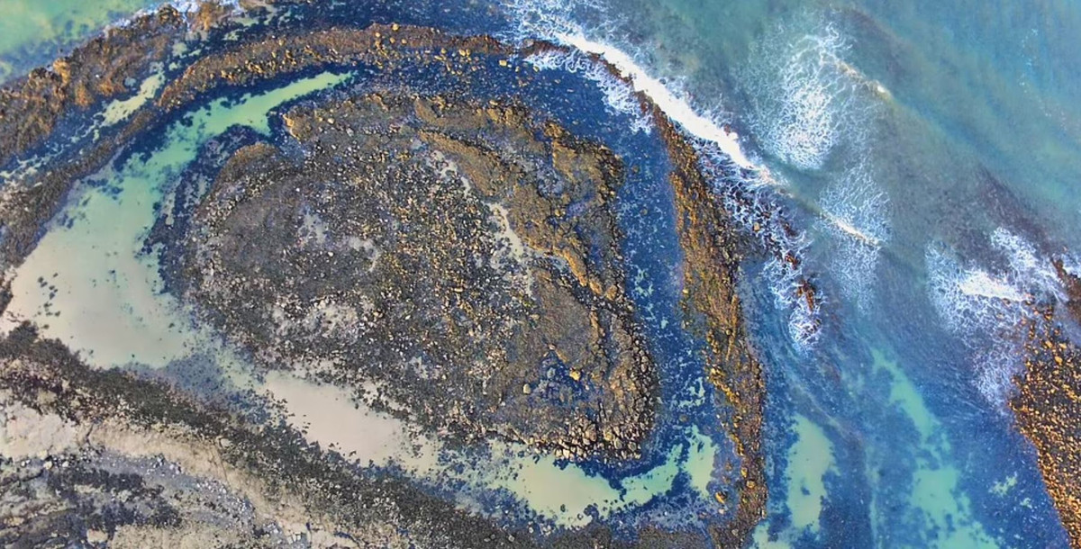 Bãi đá trên bờ biển Scotland này trông giống như một con mắt màu xanh lơ khổng lồ nhìn từ trên cao.