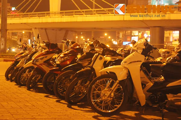 Xe máy của những người vào uống nước được các trai vẫy xếp thành hàng lên trên vỉa hè.