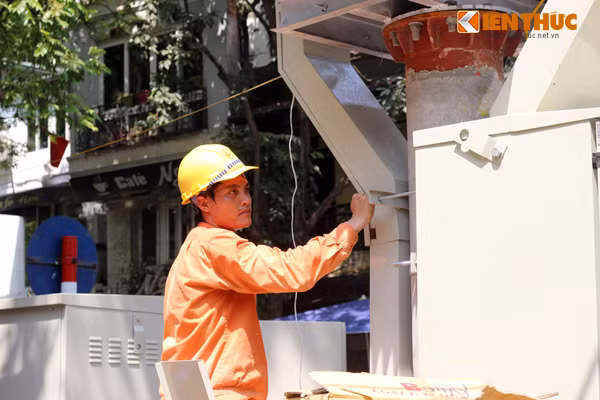 Những người thợ điện cũng không thể trì hoãn công việc vì lý do nắng nóng. Ảnh chụp trên dường Quán Thánh.