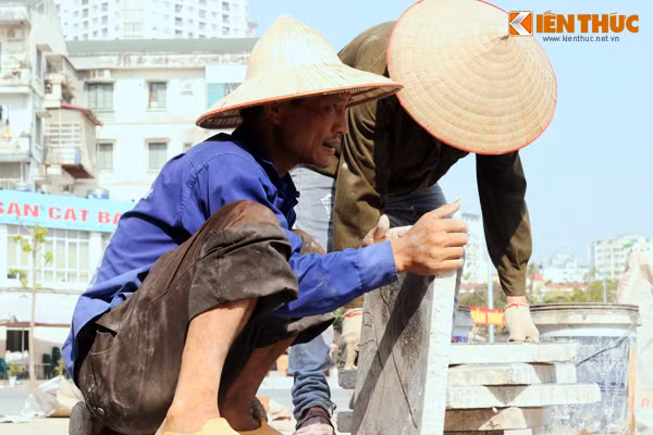 Những người đàn ông này làm việc không nghỉ tay dưới nắng trưa, trên đường Nguyễn Khánh Toàn (Hà Nội).
