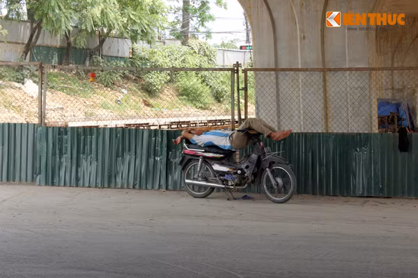 Cánh xe ôm cũng tranh thủ chui xuống gầm cầu để tránh nắng nóng. Ảnh chụp trên dốc đường Bưởi.