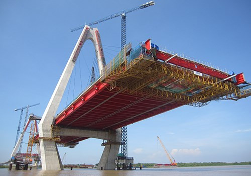 Thi công lắp hẫng nhịp cầu chính vượt sông Hồng. Mỗi đoạn dầm 12m được lắp đặt đối xứng cân bằng một cách cẩn trọng.