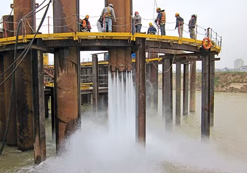 Đóng cọc dưới trụ cầu P12 sử dụng máy xói tia nước (CJ330E) .