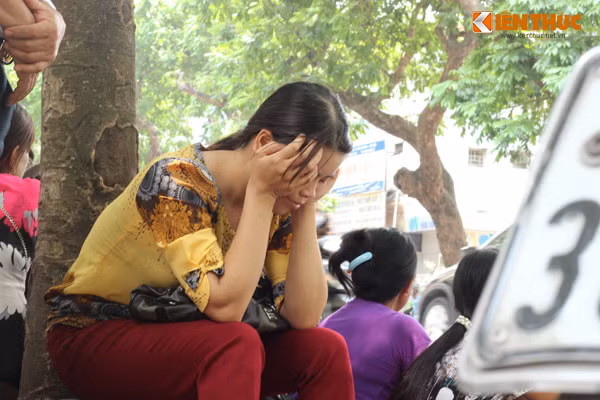 Hai tay ôm mặt mệt mỏi vì nắng nóng, chị Hoa (quê Hà Nam) chia sẻ: "Tôi lên đây từ sáng sớm, vào làm thủ tục xét nghiệm nhưng phải đợi đến chiều mới có kết quả. Ngồi chờ ngoài trời nóng quá".