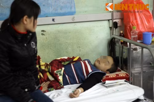 Chị Phùng Thúy Hằng ngồi buồn bã nhìn cậu con trai truyền từng giọt hóa chất vào người ở BV Nhi Trung ương.