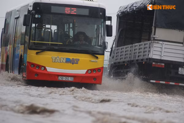 Nước ngập sâu đến nửa bánh ô tô. Ảnh: Mạnh Hưng