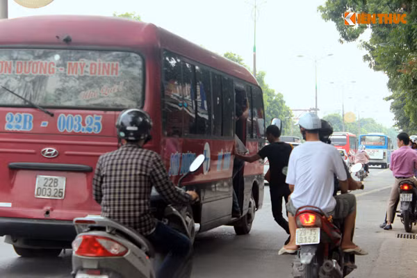 Ngay sau khi thấy khách vẫy tay ra tín hiệu, chiếc xe khách mang BKS: 21B-003.25 đang di chuyển chậm liền dừng lại ngay sát lề đường để cho khách lao lên xe.