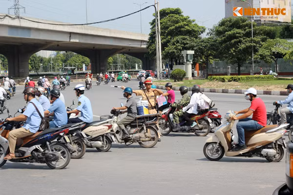Chia sẻ với PV Kiến Thức, Thiếu úy Vũ Đình Long, Đội CSGT số 6 cho biết: "Nắng nóng nhưng chúng tôi vẫn phải cố gắng làm việc và điều tiết giao thông vì đây là một trong những nút giao thông trọng điểm, chỉ cần xảy ra một va chạm nhỏ sẽ khiến đoạn đường ùn tắc ngay". Ảnh chụp tại Ngã tư Khuất Duy Tiến - Nguyễn Trãi (Hà Nội) sáng 27/5.