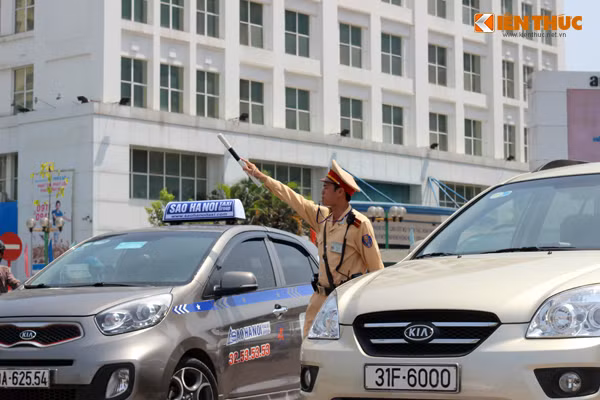 Ảnh một chiến sĩ CSGT liên tục chỉ dẫn các phương tiện giữa trưa nắng như đổ lửa.