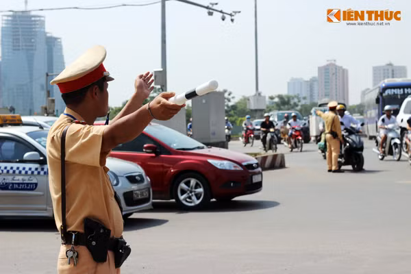 Tại nút giao thông Ngã tư Khuất Duy Tiến - Nguyễn Trãi (Hà Nội), nắng như đổ lửa nhưng 2 chiến sỹ CSGT, Đội CSGT số 6 vẫn đứng giữa đường để điều tiết giao thông.