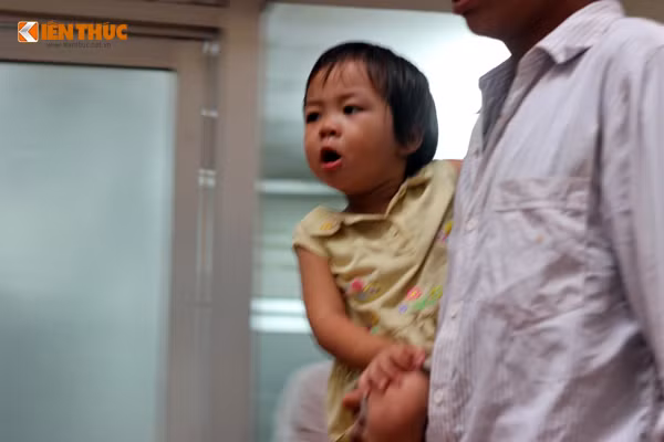 Nước mắt chảy giàn giụa trên khuôn mặt một bé gái. Em khóc rất to, kèm theo tiếng nấc cụt khi người bố bế đưa vào phòng khám.