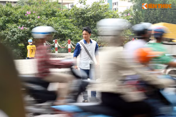 Nam sinh mắc kẹt vài phút giữa dòng xe máy mới sang được điểm xe buýt.