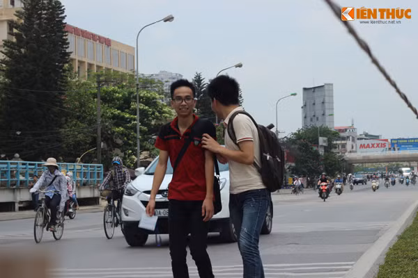 Mặc dù đã băng qua được đoạn đường trước cổng trường ĐH GTVT nhưng 2 nam sinh phải chia nhau quan sát trước - sau tránh ô tô, xe máy.