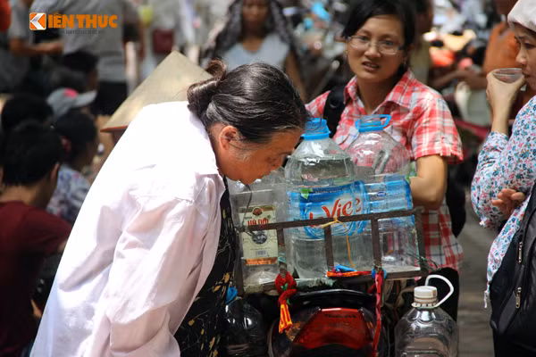 Dù nắng nóng nhưng bà Thũng vẫn vui vẻ mang những cốc nước vối mát lạnh miễn phí cho mọi người ở Bệnh viện K.