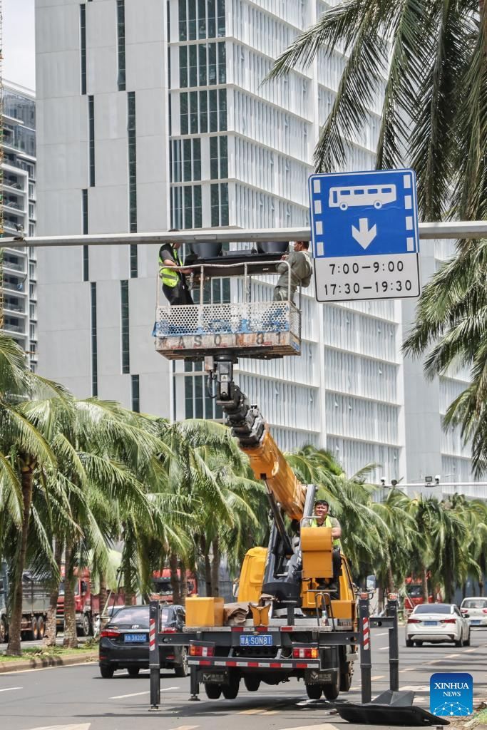 Công nhân sửa đèn giao thông trên đường ở Hải Khẩu sau bão.