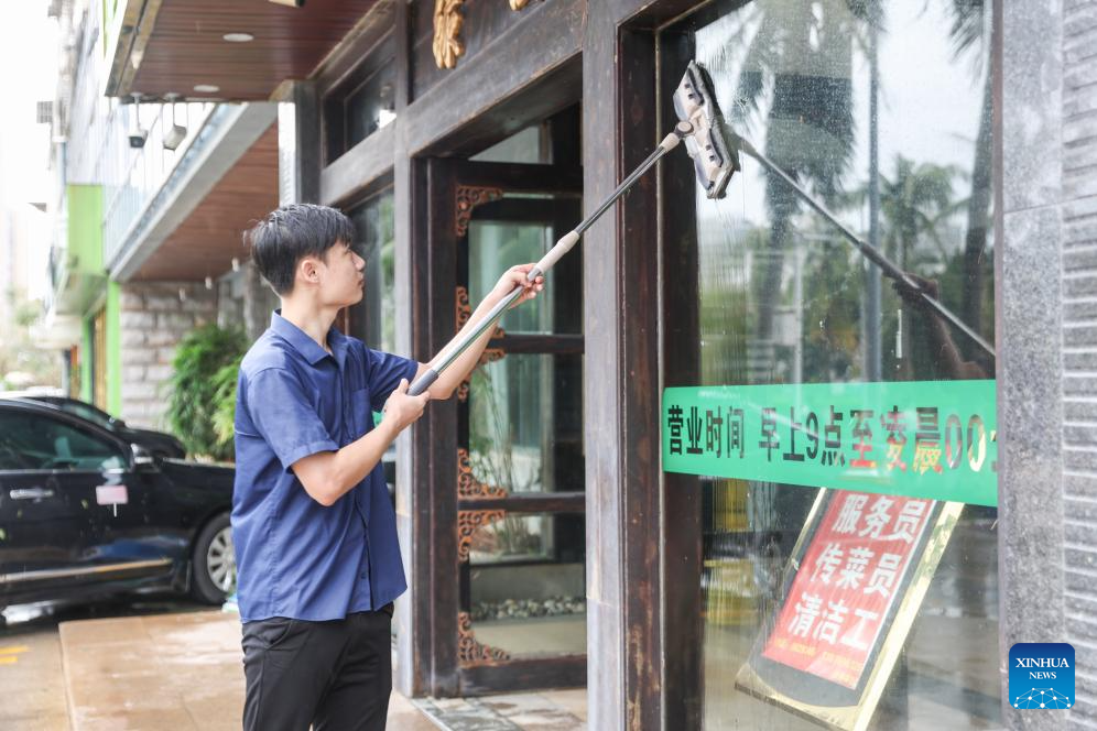 Một người đàn ông lau cửa của một nhà hàng ở Hải Khẩu, tỉnh Hải Nam, ngày 7/9.
