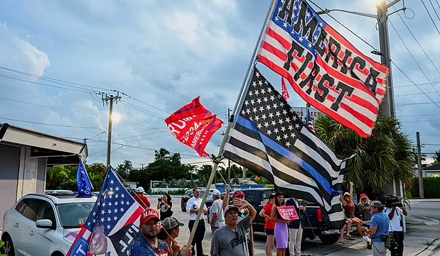 Trong khi đó, con trai của Wesley Routh, Oran Routh, khẳng định cha mình không phải là người bạo lực và thậm chí không tin ông sở hữu súng. Ảnh: Những người ủng hộ ông Trump tập trung quanh Mar-A-Lago, sau khi ứng cử viên Tổng thống Đảng Cộng hòa và cựu Tổng thống Mỹ Donald Trump trở về từ câu lạc bộ golf quốc tế Trump, nơi xảy ra vụ nổ súng.