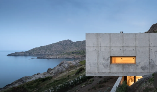 Được xây dựng vào năm 2021, ngôi nhà này bám vào những ngọn núi ở Port de la Selva, Tây Ban Nha. Ngôi nhà do Marià Castelló và José Antonio Molin thiết kế, bê tông nguyên chất được lựa chọn để phù hợp với các đặc điểm địa chất cũng như làm cho cấu trúc chắc chắn, giảm thiểu việc bảo trì.