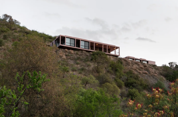 Ngôi nhà này do Alarciaferrer Arquitectos thiết kế, nhìn ra thung lũng Camlamuchita ở Argentina và có hai tầng: Tầng trên nhô ra trên núi, chủ yếu dành cho không gian chung, và tầng dưới có phòng ngủ, hồ bơi.