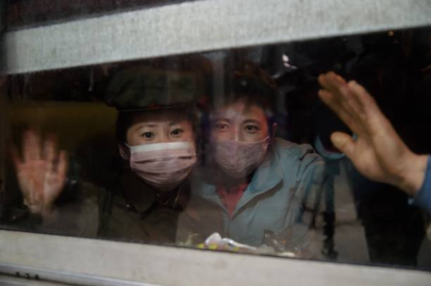 Trong bức ảnh chụp ngày 20/11/2020 này, các đảng viên vẫy tay chào khi chuẩn bị xuống tàu tại ga xe lửa trung tâm Bình Nhưỡng. Họ trở về sau khi được triển khai đến các tỉnh nông thôn để hỗ trợ nỗ lực phục hồi sau thiệt hại do cơn bão tháng 9 gây ra.