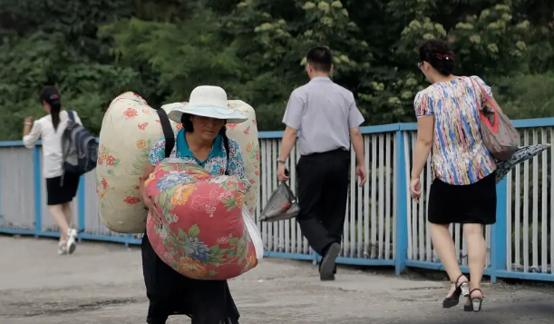 Người phụ nữ lớn tuổi mang theo đồ đạc trở về sau ngày làm việc ở Bình Nhưỡng.
