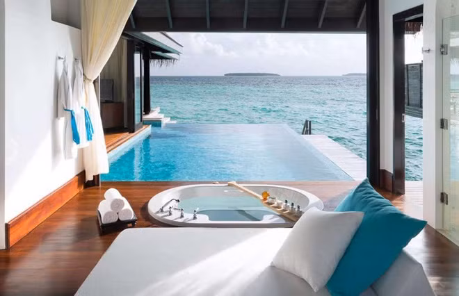 Một phòng tắm xa hoa khác nằm trong dinh thự Anantara Kihavah Sunset trên đảo Kihavah Huravalhi, Maldives. Nằm kế bên bể bơi vô cực, phòng tắm có thiết kế tối giản với bồn tắm đáy kính.