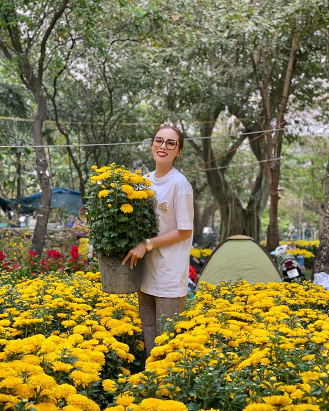 Người đẹp diện bộ đồ giản dị, tươi tắn chụp hình bên những chậu cúc vàng.