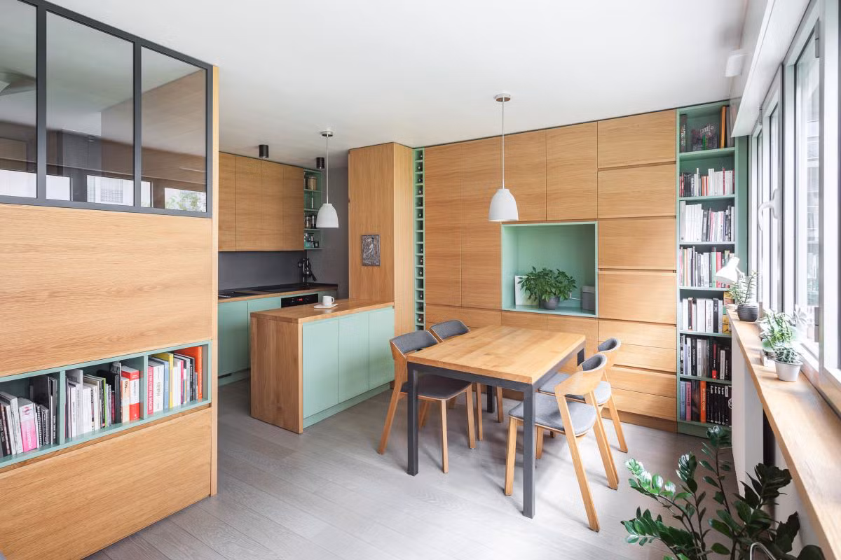 Các bức tường đều được thiết kế hệ thống kệ, tủ linh hoạt, kết hợp màu gỗ sồi cùng với màu xanh lá cây. Căn phòng không chỉ được decor khéo léo với nội thất mà còn tạo độ thẩm mỹ vô cùng tinh tế giúp không gian rộng rãi dù có hạn chế về diện tích.