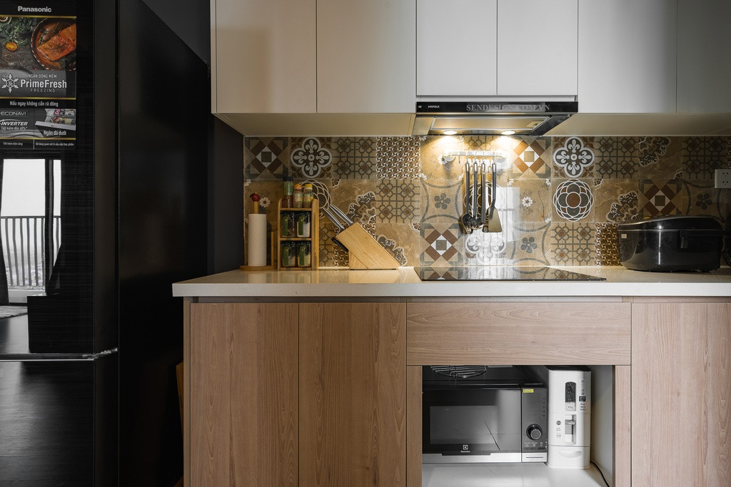 Khu vực bếp được trang trí với gạch men hoạ tiết tạo điểm nhấn nhưng vẫn hài hòa với tông màu chủ đạo của căn hộ. Cùng với đó là các dụng cụ bếp cơ bản dành cho người độc thân.