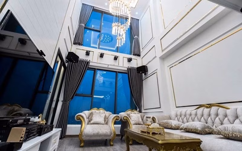 Căn nhà được trang trí theo phòng cách hoàng gia, châu Âu với tông màu chủ đạo là trắng - vàng, tạo vẻ xa hoa. Chất liệu kính được tận dụng làm không gian nhà thêm mở rộng.