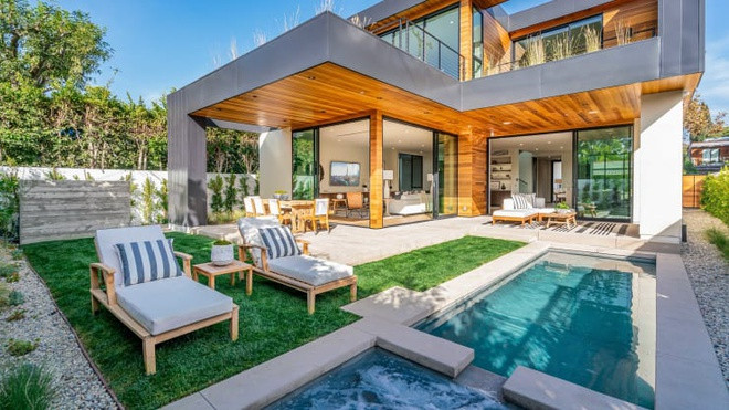 Phía sau nhà thiết kế một sân sau nhỏ, ở đây có hồ bơi, spa cùng những bãi cỏ xanh mát và lô gia có mái che để dùng bữa ngoài trời. Ảnh: CNBC.