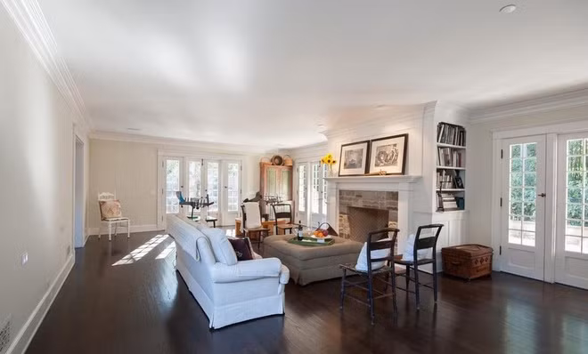 Phòng khách rộng rãi với những nội thất mang màu sắc hoài cổ. Những cánh cửa bao quanh căn phòng đem đến ánh sáng tự nhiên và mở ra không gian sân vườn.