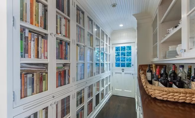 Một hành lang độc đáo với một bên là chiếc tủ sách âm tường cỡ lớn và bên còn lại là chiếc tủ bếp.