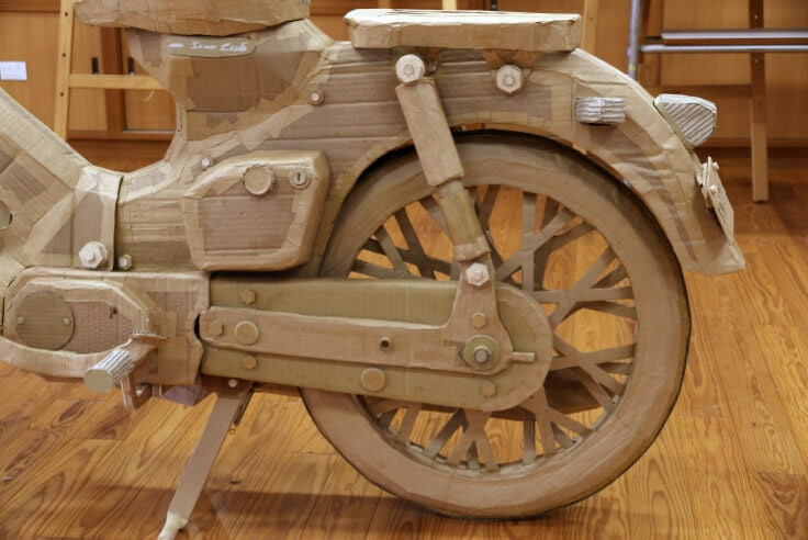 Được biết, nhóm đã phải tìm hiểu về kỹ thuật xử lý bìa carton để ứng dụng vào dự án. Họ đã hao tốn khá nhiều giấy bìa cứng ở giai đoạn đầu khi chưa thể tạo hình các bề mặt như ý muốn. Chi tiết được làm đầu tiên là bánh xe, các phần khó thực hiện cũng như tốn nhiều thời gian nhất gồm tay lái, yếm xe và phuộc trước.