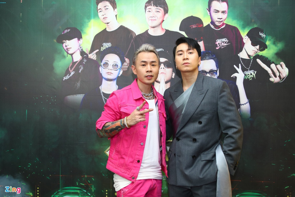 Khác với Wowy, Binz lựa chọn trang phục màu hồng neon nổi bật. Đây là màu sắc yêu thích của rapper người Gia Lai, thường xuất hiện trong trang phục đời thường của anh. Karik chọn bộ suit màu xám lịch lãm, sang trọng.