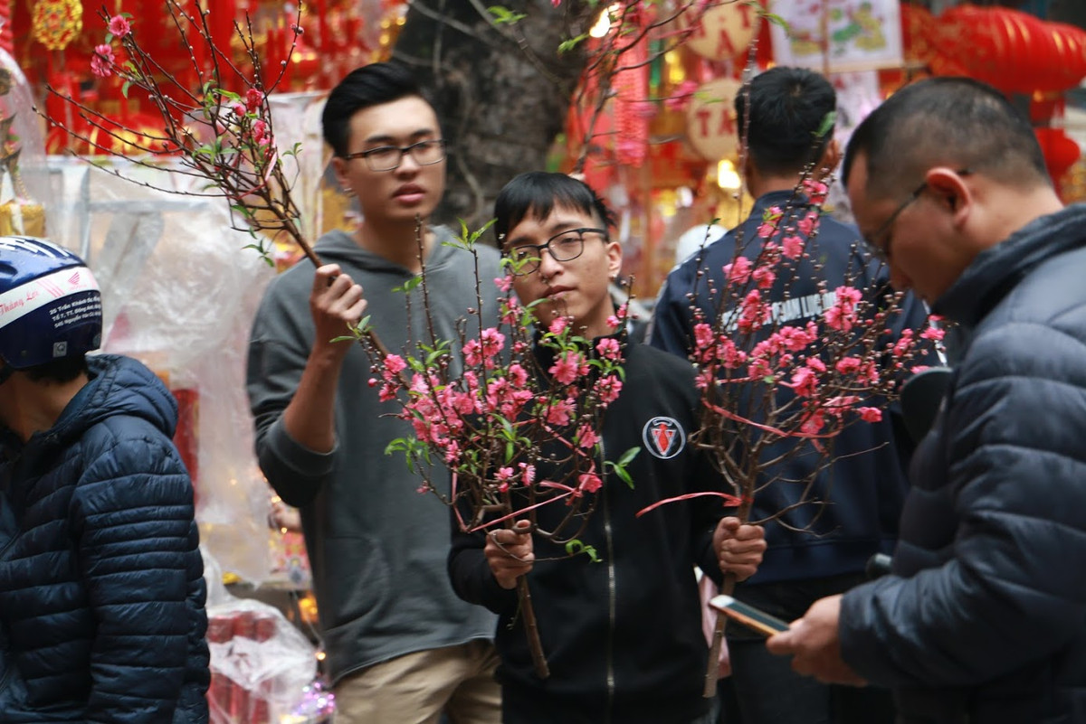 Ngoài việc kinh doanh các vật phẩm trang trí nhà, năm nay nhiều hộ dân trên phố Hàng Mã cũng chuyển sang buôn những cành đào nhỏ về bày trên bàn thờ.