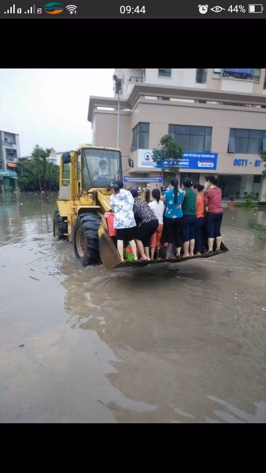 Một số cư dân thuộc một chung cư trên địa bàn Hà Nội đã phải nhờ tới chiếc máy xúc để vượt qua chỗ nước sâu để tới chỗ làm.
