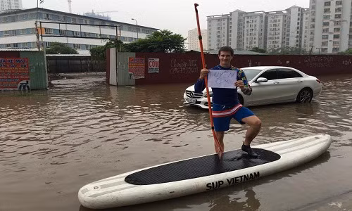 Thậm chí, anh chàng còn vui tính cầm biển "thuyền ôm", sẵn sàng giúp đỡ những ai có nhu cầu vượt qua đoạn đường ngập lụt. Có vẻ như chàng trai đã rất quen thuộc với tình trạng cứ mưa lớn là đường lại ngập lụt nghiêm trọng ở Hà Nội.