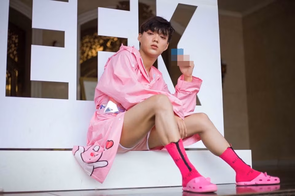 Khác hẳn với tone màu trầm được phần đông các bạn trẻ lựa chọn "thánh chửi" Norin Phạm lại diện bộ trang phục hồng rực rỡ với họa tiết hoạt hình, bên cạnh đó là đôi tất hồng và dép nhựa hở lỗ "ton sur ton".