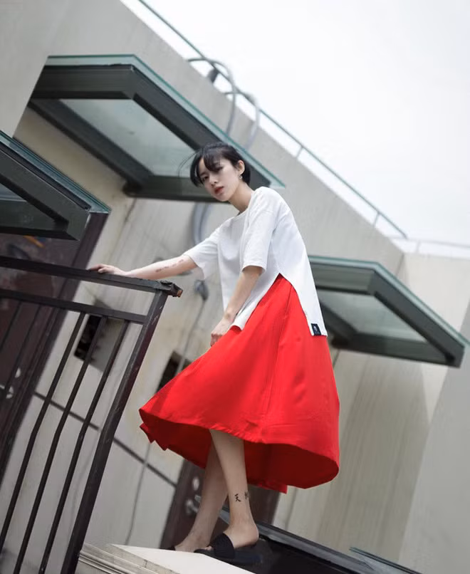 Vẫn dịu dàng trong chiếc váy dài màu đỏ nhưng với những hình xăm trên người, Ngộ Không không hề kém cá tính. Ảnh sử dụng trong bài: Instagram nhân vật.