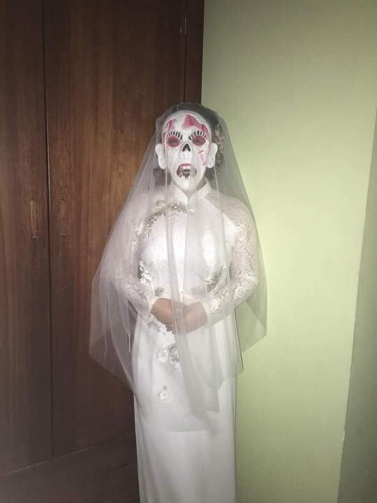 Theo đó, trang phục cô dâu này chọn là áo dài trắng kèm thêm chiếc mặt nạ quỷ và phủ lên đầu chiếc khăn voan trắng đầy kinh dị.