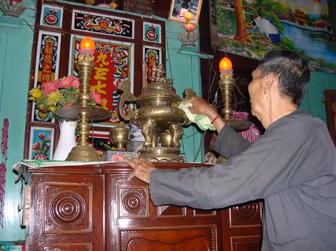 Lão nông ở Đồng Tháp lau chùi bàn thờ trong nhà