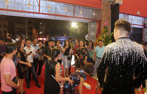 Do quy định không được chạm vào hiện vật trưng bày, hàng trăm khán giả đứng vây xung quanh để chụp ảnh và ngắm chân dung sáp Đàm Vĩnh Hưng (phải). Mọi người không ngớt bàn tán, nhận xét về tác phẩm này.