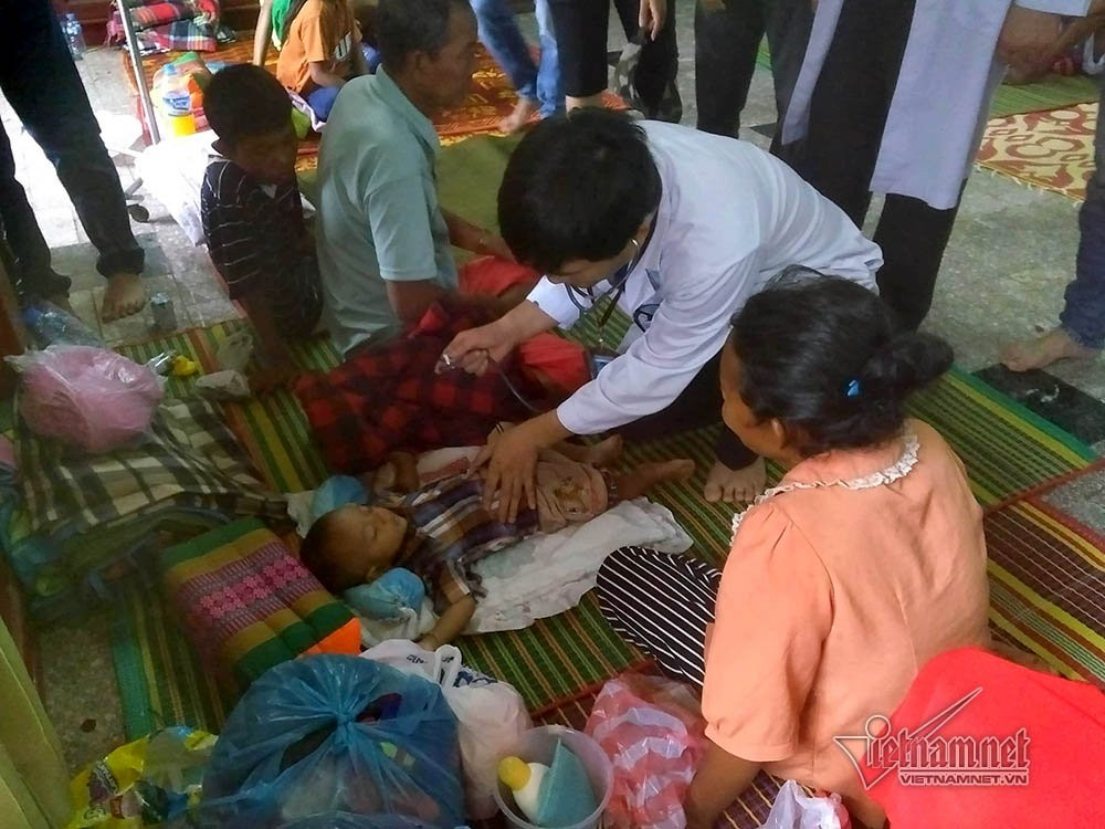 Bác sĩ nghe khám phổi cho em bé 9 tháng tuổi vừa thoát khỏi lũ dữ