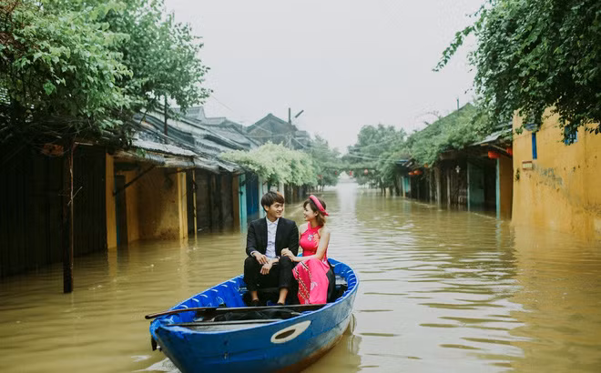Những ngày qua, thông tin bão số 12 đổ bộ liên tục được các kênh thông tin cũng như cộng đồng mạng cập nhật. TP Hội An là một trong số những thành phố đang phải hứng chịu cảnh nước lũ dâng cao, ngập úng nặng. Tuy nhiên, giữa khung cảnh mênh mông nước lũ ấy, vẫn có những hình ảnh, vẫn có những khoảnh khắc hạnh phúc của lứa đôi được lưu lại. Ảnh trong bài: Rin Wedding