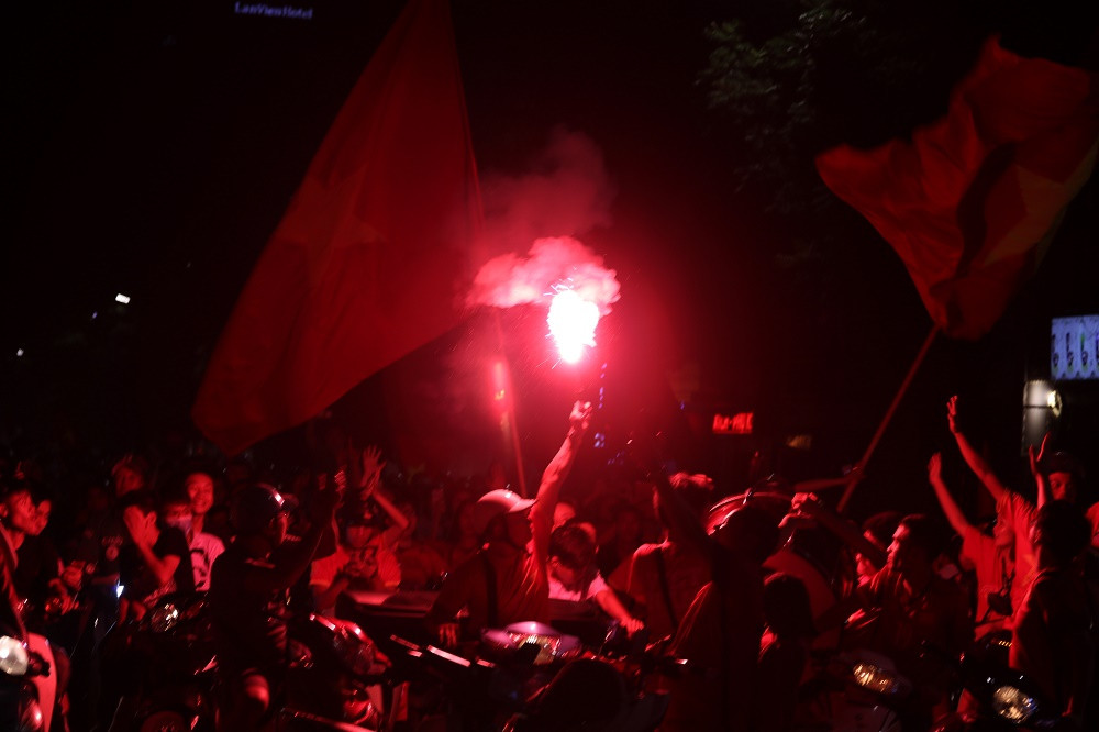 Các CĐV của Hội CĐV VFS Miền Bắc đốt pháo sáng, reo hò ăn mừng sau chiến thắng của đội tuyển Olympic Việt Nam trước Bahrain.