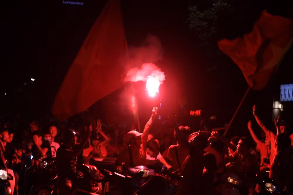 Các CĐV của Hội CĐV VFS Miền Bắc đốt pháo sáng, reo hò ăn mừng sau chiến thắng của đội tuyển Olympic Việt Nam trước Bahrain.