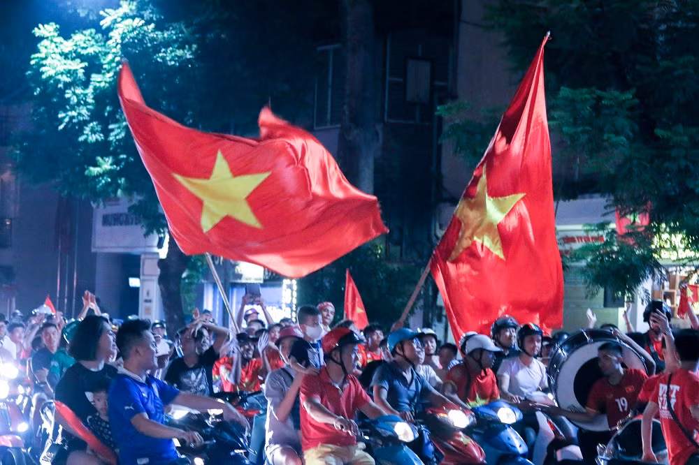 Có mặt tại những con phố quanh khu vực Hồ Gươm tối ngày 23/8, không khí náo nhiệt hơn bao giờ hết. Người hâm mộ các cầu thủ Olympic Việt Nam với cờ, trống và vật dụng cổ vũ đã ra đường, tạo nên bầu không khí lễ hội.