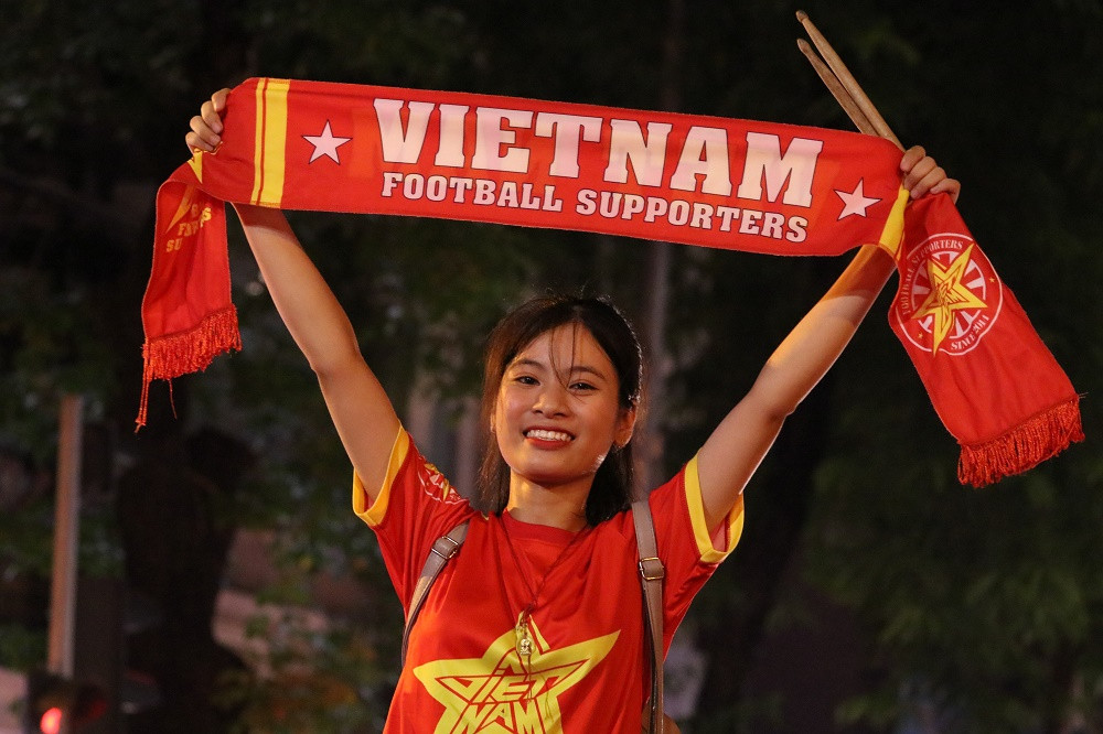 Chuẩn bị đủ các dụng cụ như áo, cờ... CĐV nữ thuộc Hội CĐV VFS Miền Bắc này luôn là người cầm nhịp cho những màn cổ vũ của các "đồng đội". Theo chia sẻ của bạn nữ, đây chẳng khác gì một khán đài D8 của sân Mỹ Đình vì họ được chơi những điệu cổ vũ mà đã ngấm vào máu.